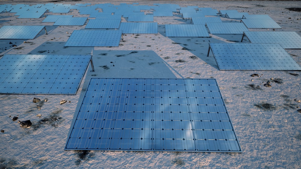 um grupo de painéis solares sentados no topo de uma praia de areia