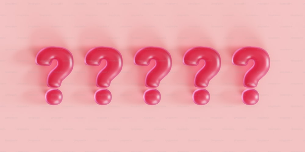 Un gruppo di punti interrogativi rosa su sfondo rosa