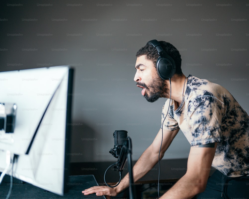 a man with headphones on looking at a computer screen