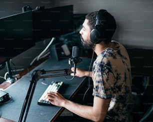 a man wearing headphones sitting in front of a microphone