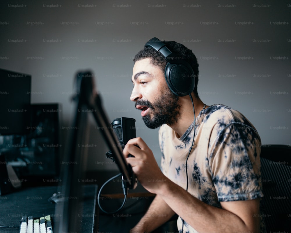 um homem com fones de ouvido sentado na frente de um microfone
