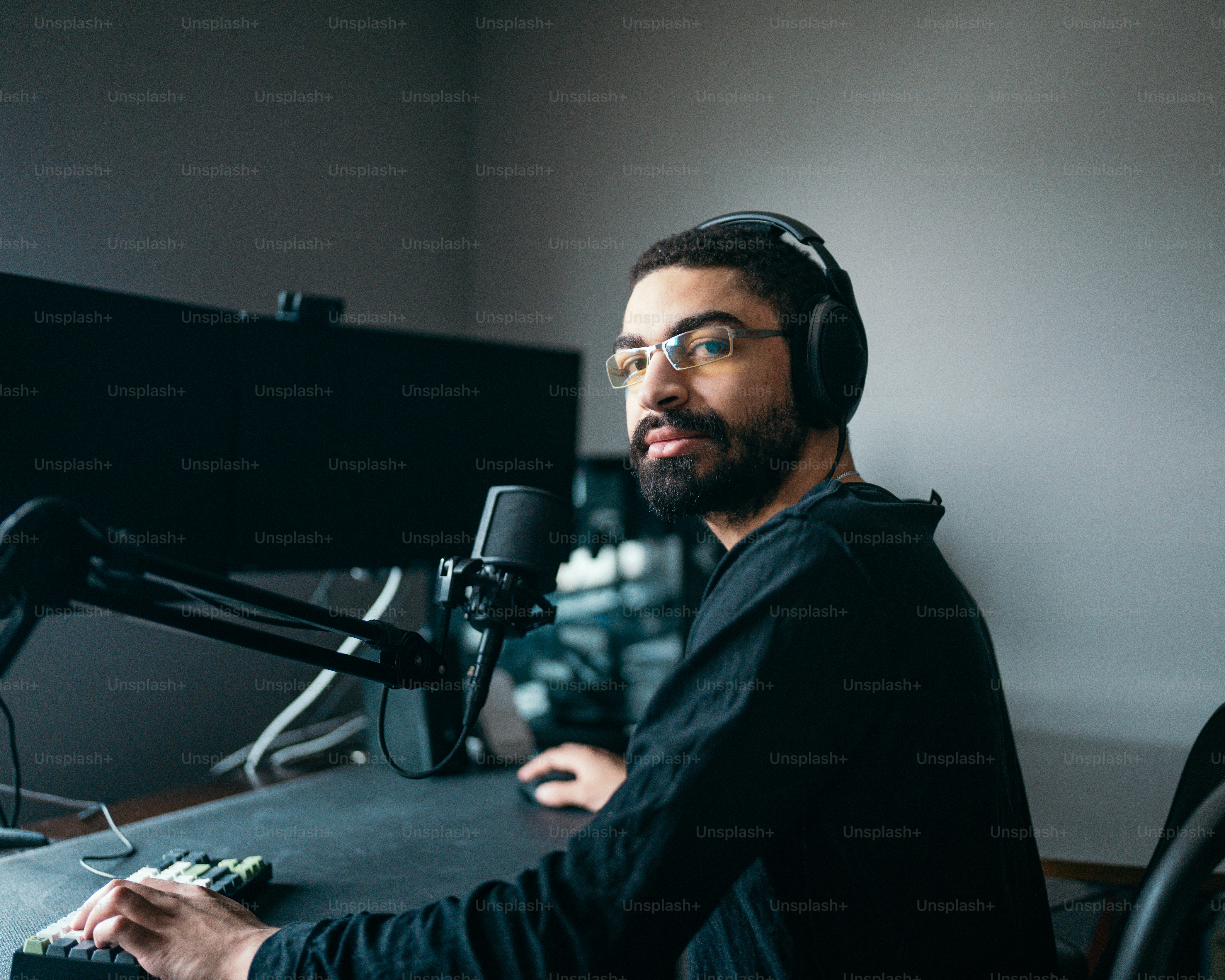 a man wearing headphones sitting in front of a microphone