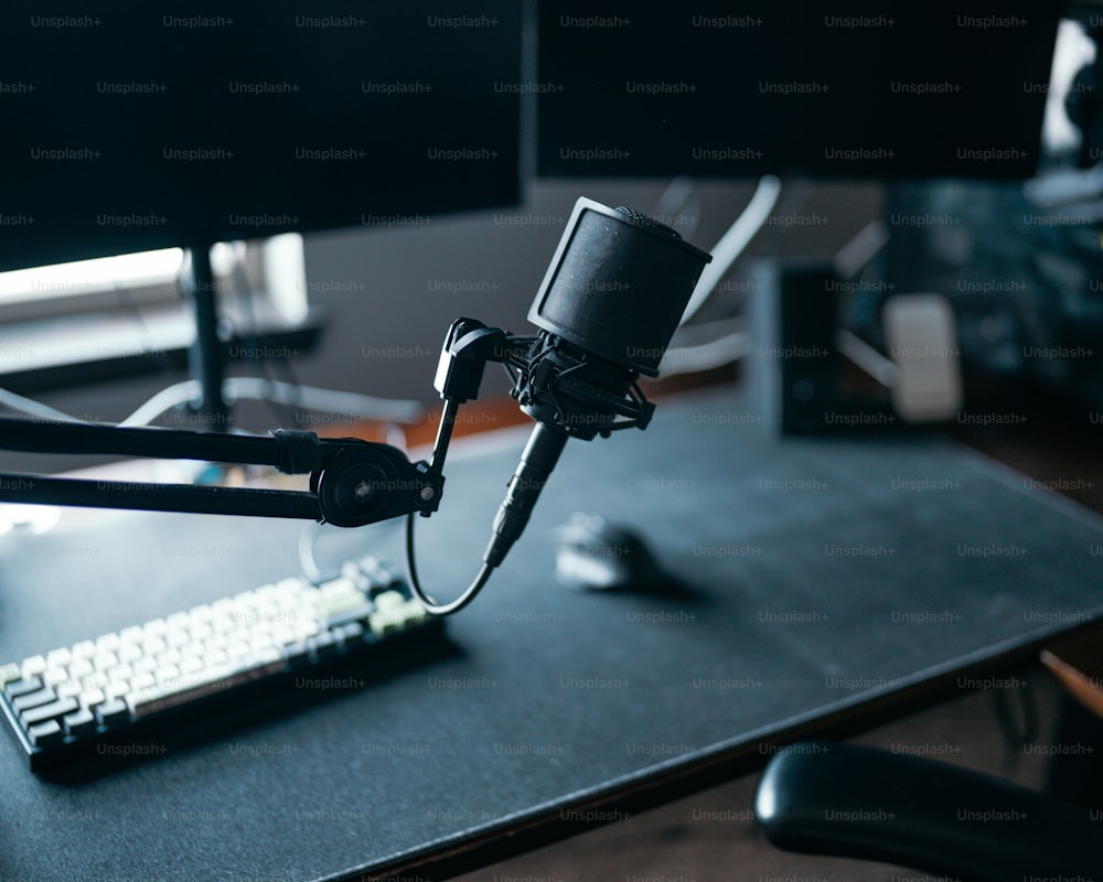 ein Mikrofon, das an einen Computermonitor auf einem Schreibtisch angeschlossen ist