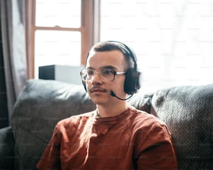 a man sitting on a couch wearing a headset