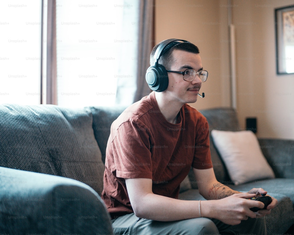 a man sitting on a couch wearing headphones