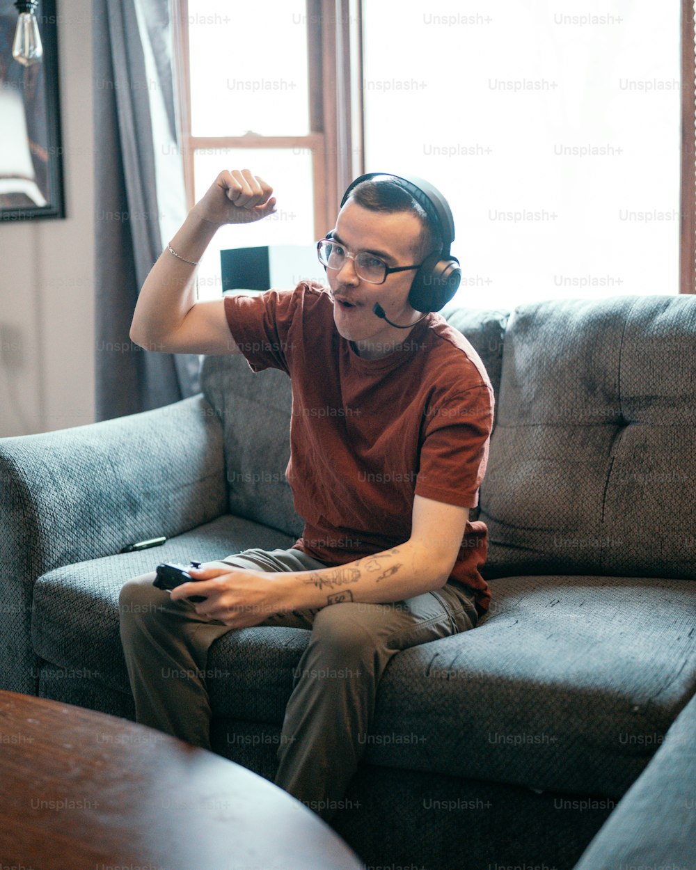 um homem sentado em um sofá com fones de ouvido em