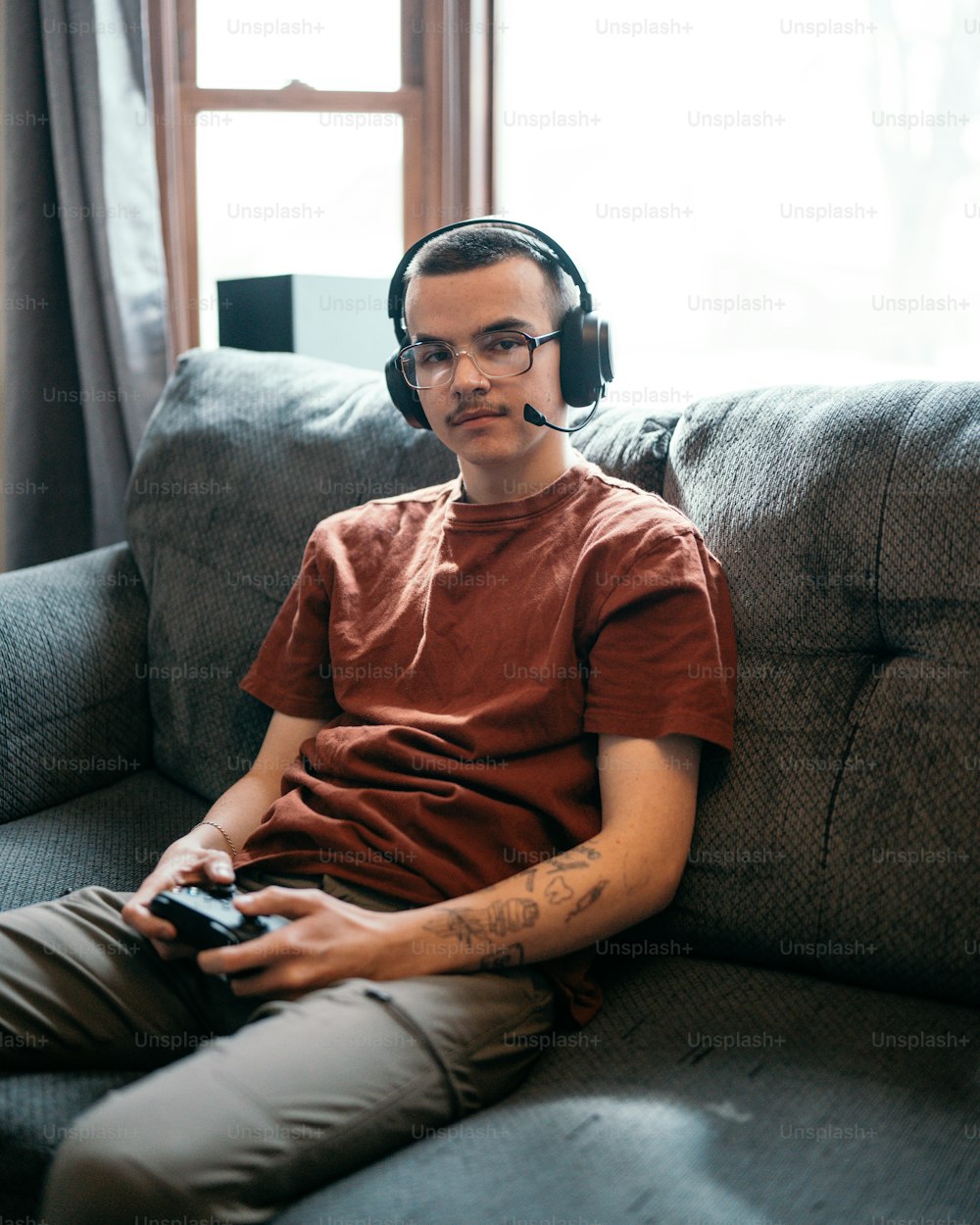 a man sitting on a couch wearing headphones