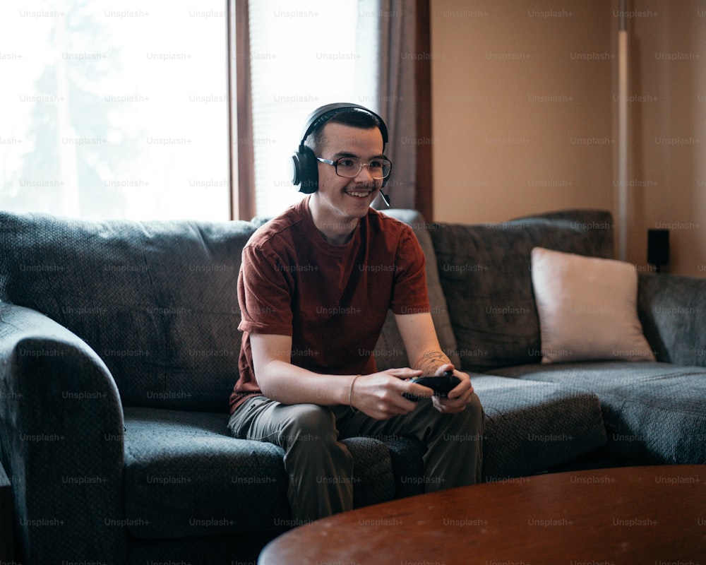 Ein Mann, der auf einer Couch sitzt und ein Videospiel spielt