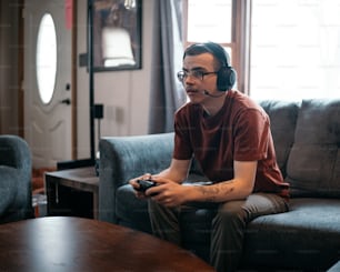 a man sitting on a couch holding a remote control