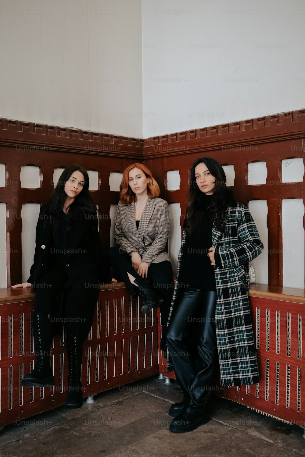 Drei Frauen sitzen auf einer Bank in einem Gebäude