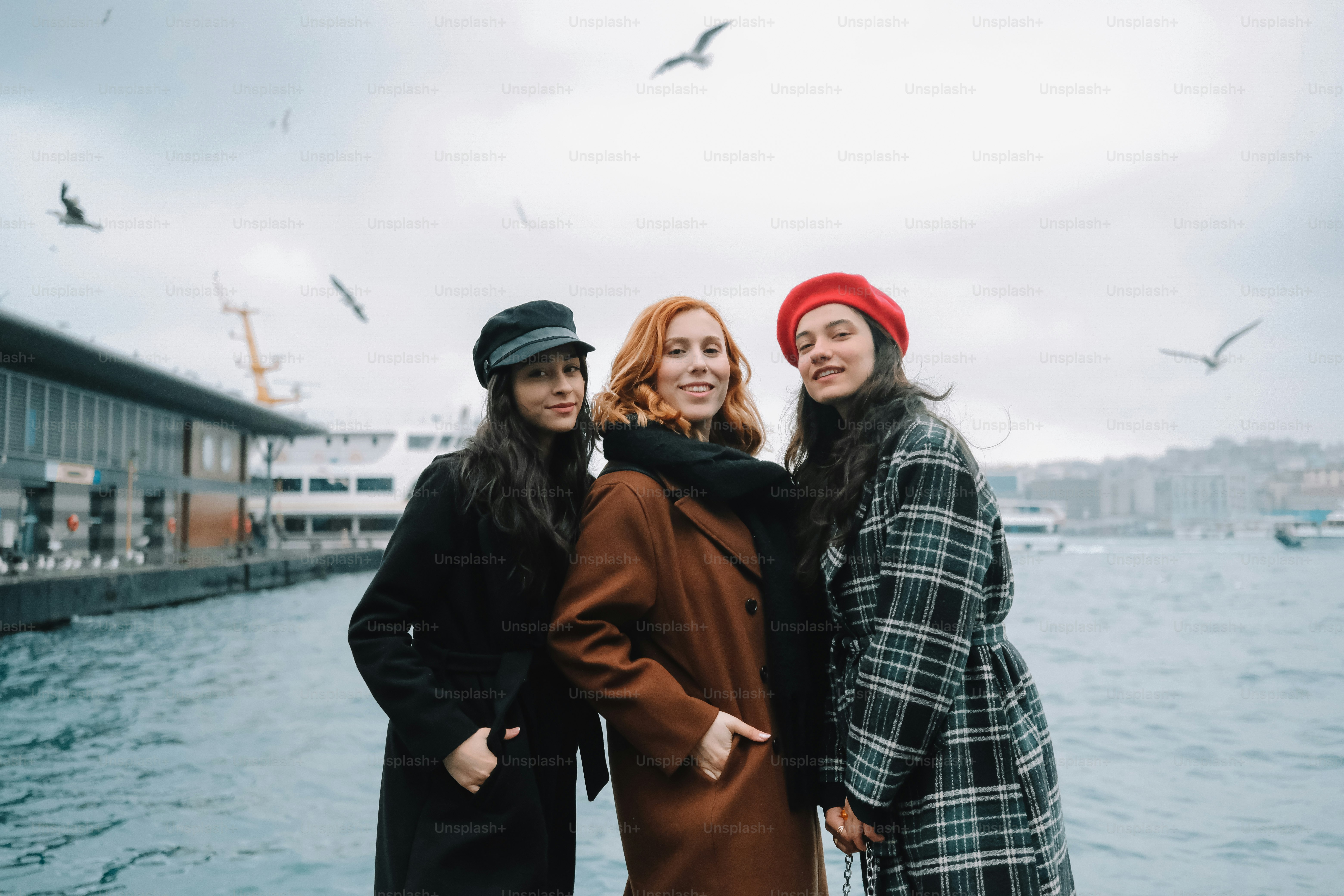 um grupo de três mulheres de pé uma ao lado da outra