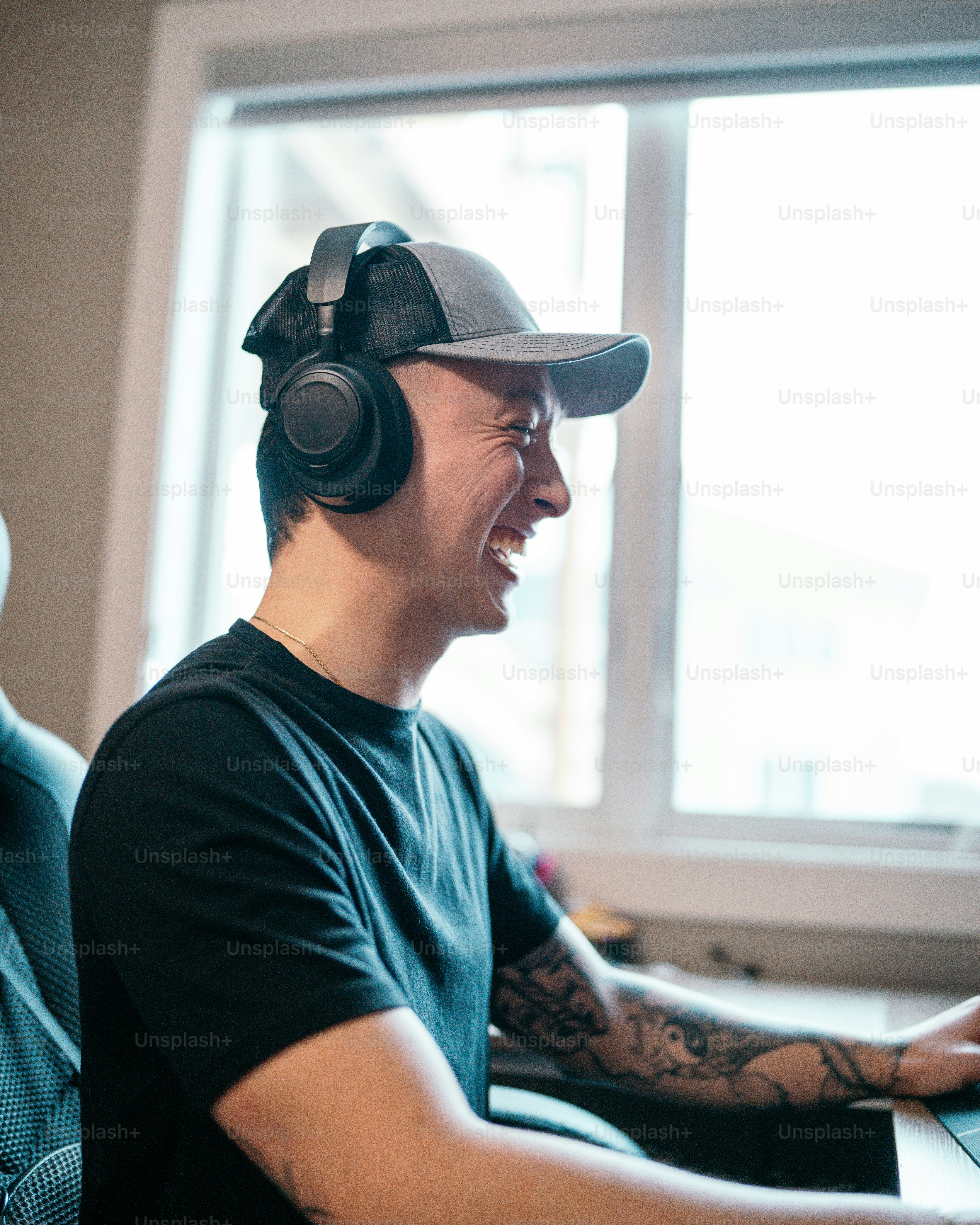 A man wearing headphones sitting in front of a laptop computer photo ...