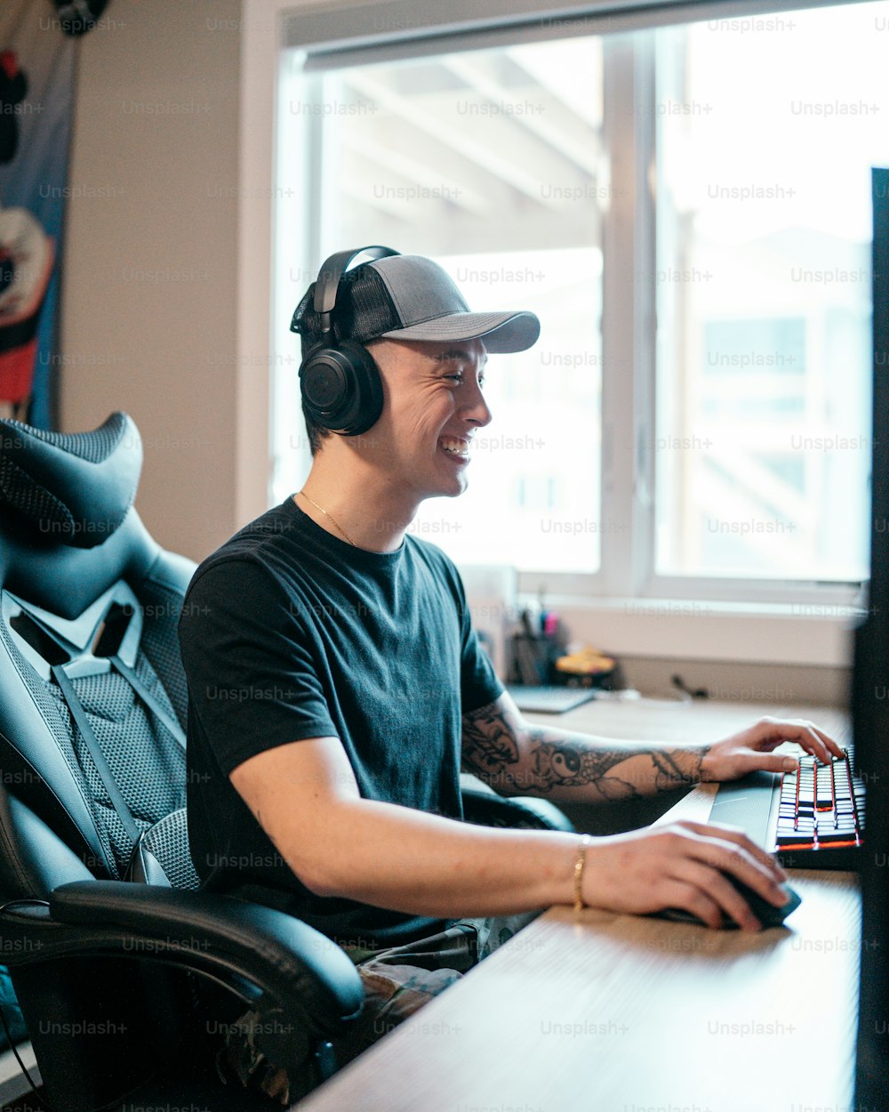 a man sitting at a desk with a laptop and headphones on