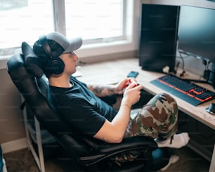 a man sitting in front of a computer with headphones on