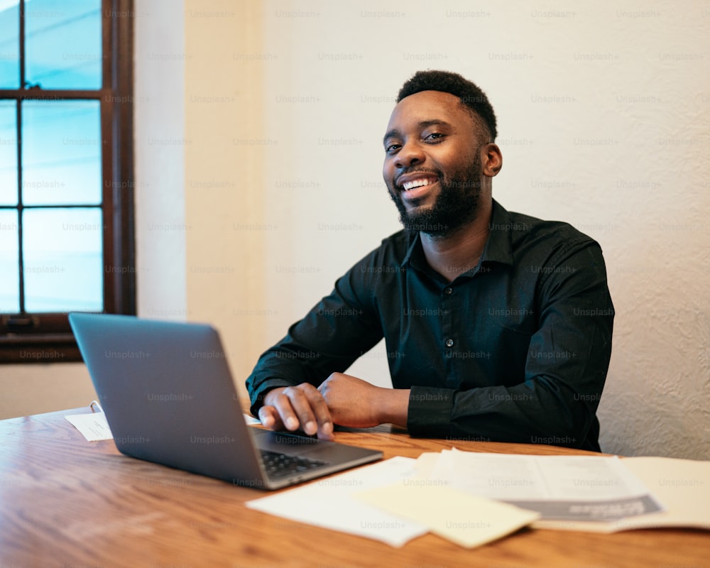 a man sitting at a table with a laptop