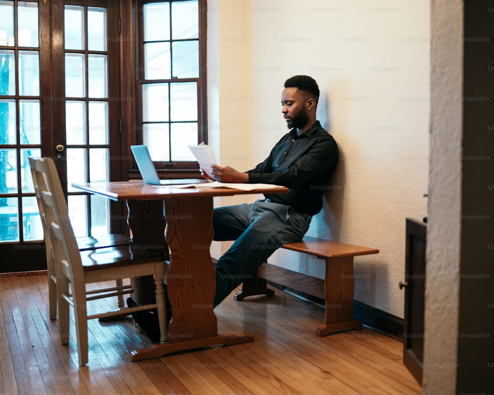 Un uomo seduto a un tavolo con un computer portatile