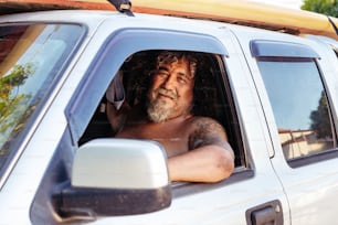 a man in a white truck with a surfboard on top of his head