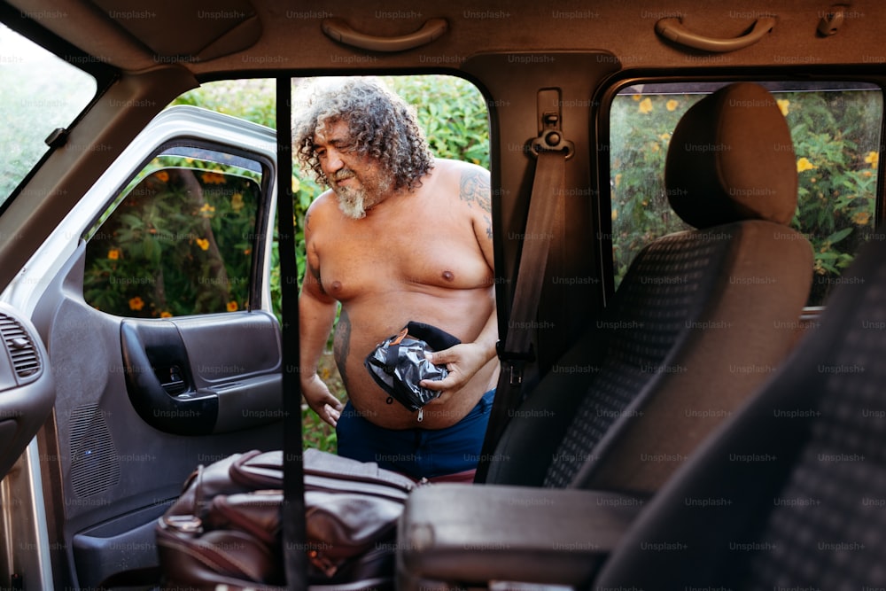 a man with no shirt standing in the back of a truck