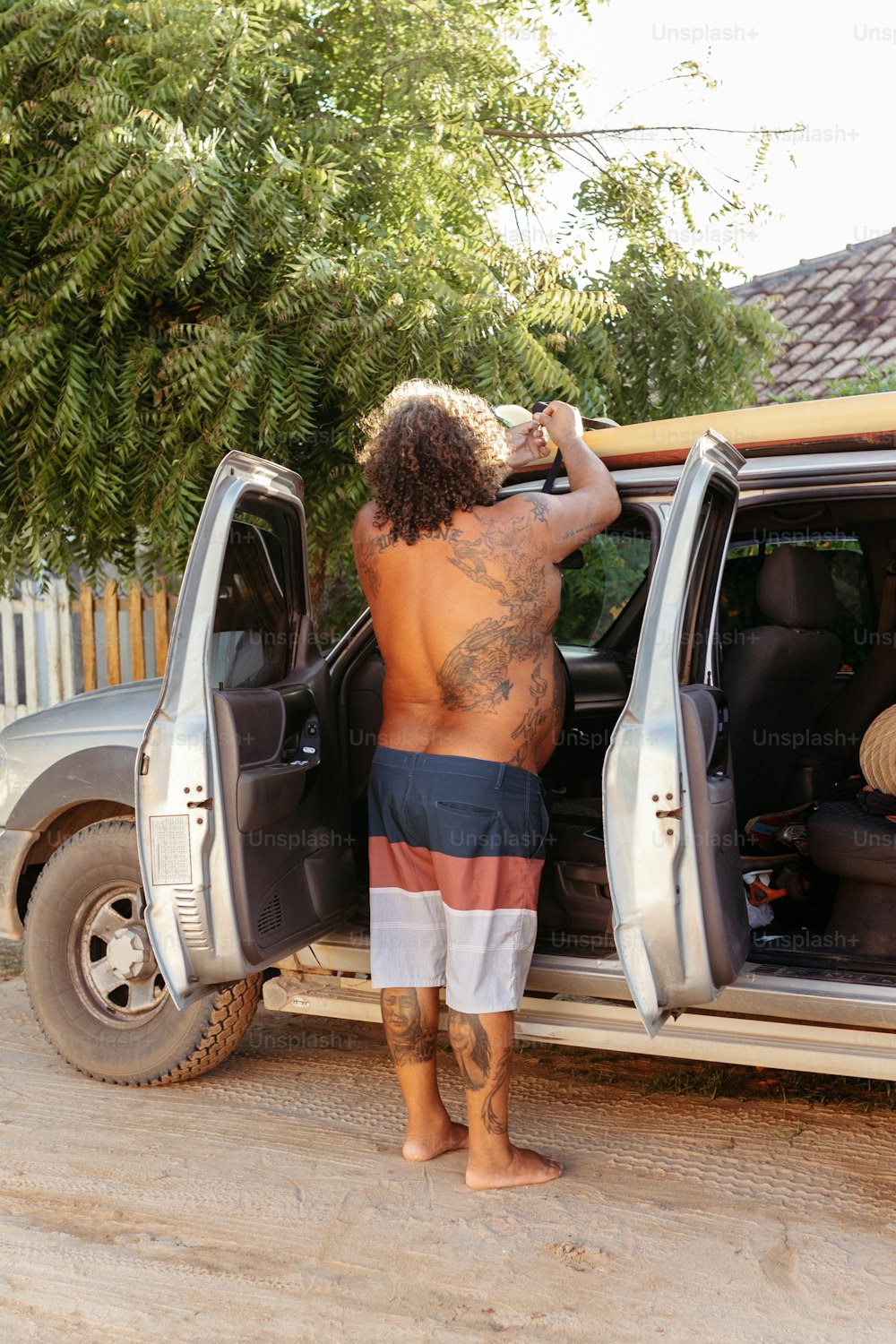 a man with long hair standing in the back of a truck