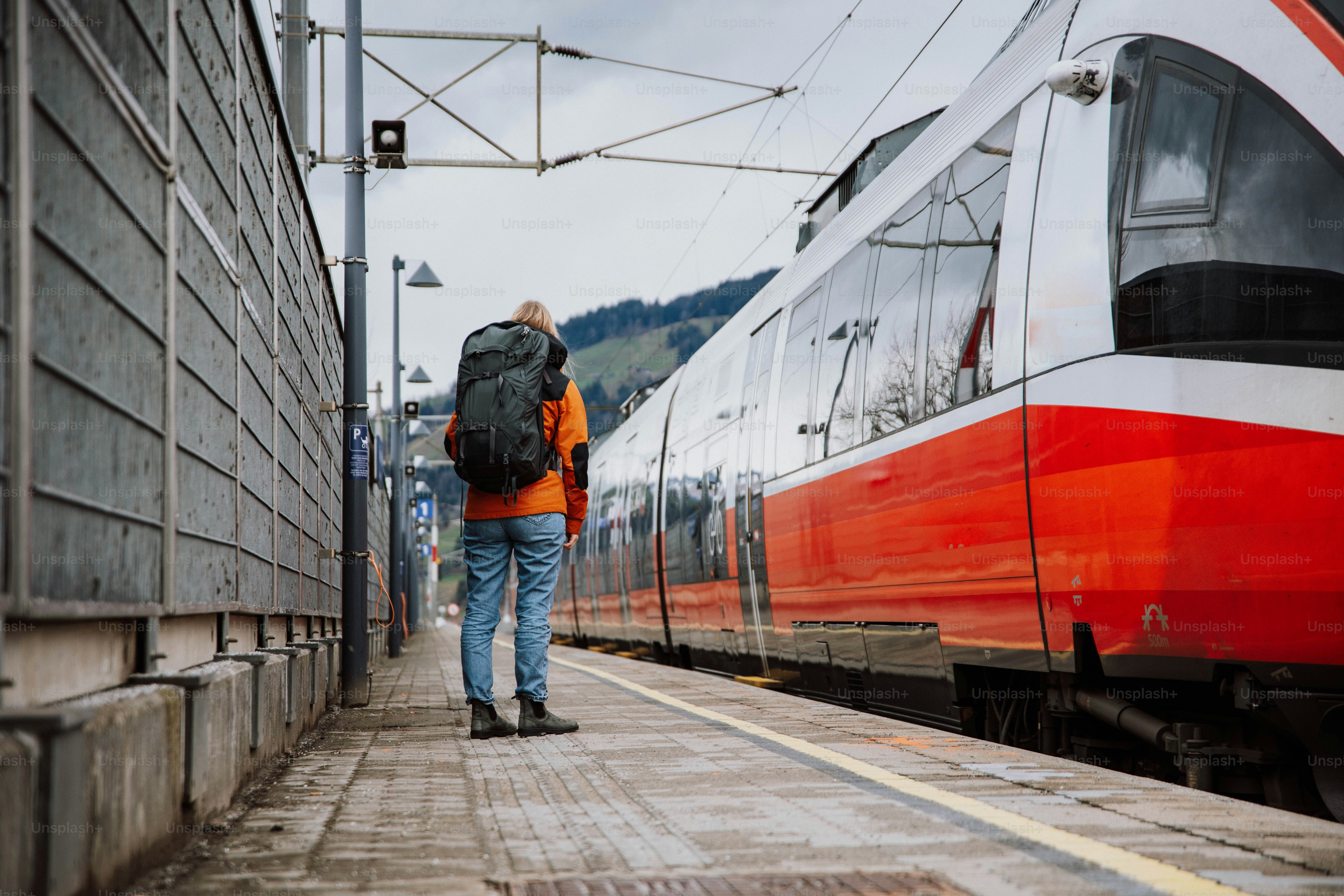 a man with a backpack is waiting for a train