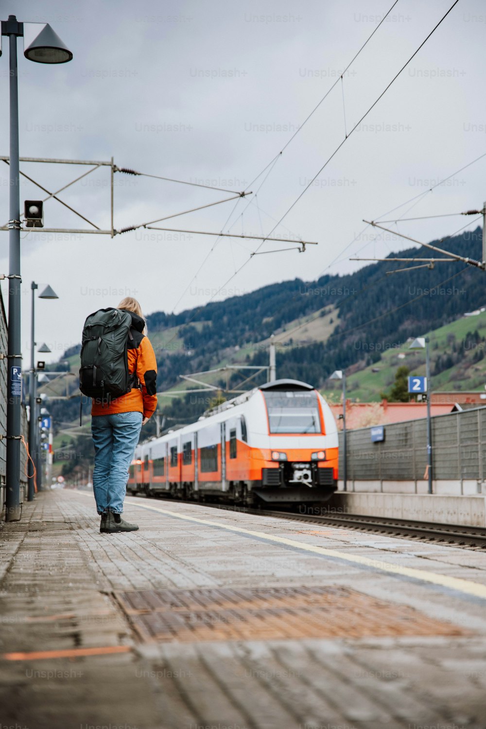 um homem com uma mochila caminhando em direção a um trem