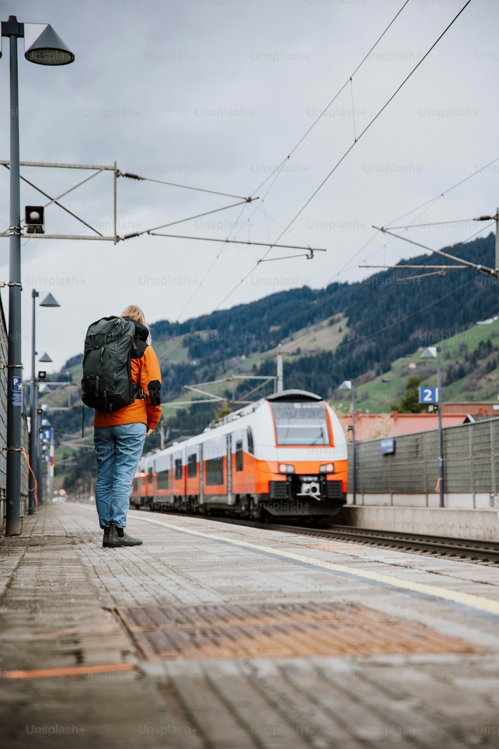 a man with a backpack walking towards a train