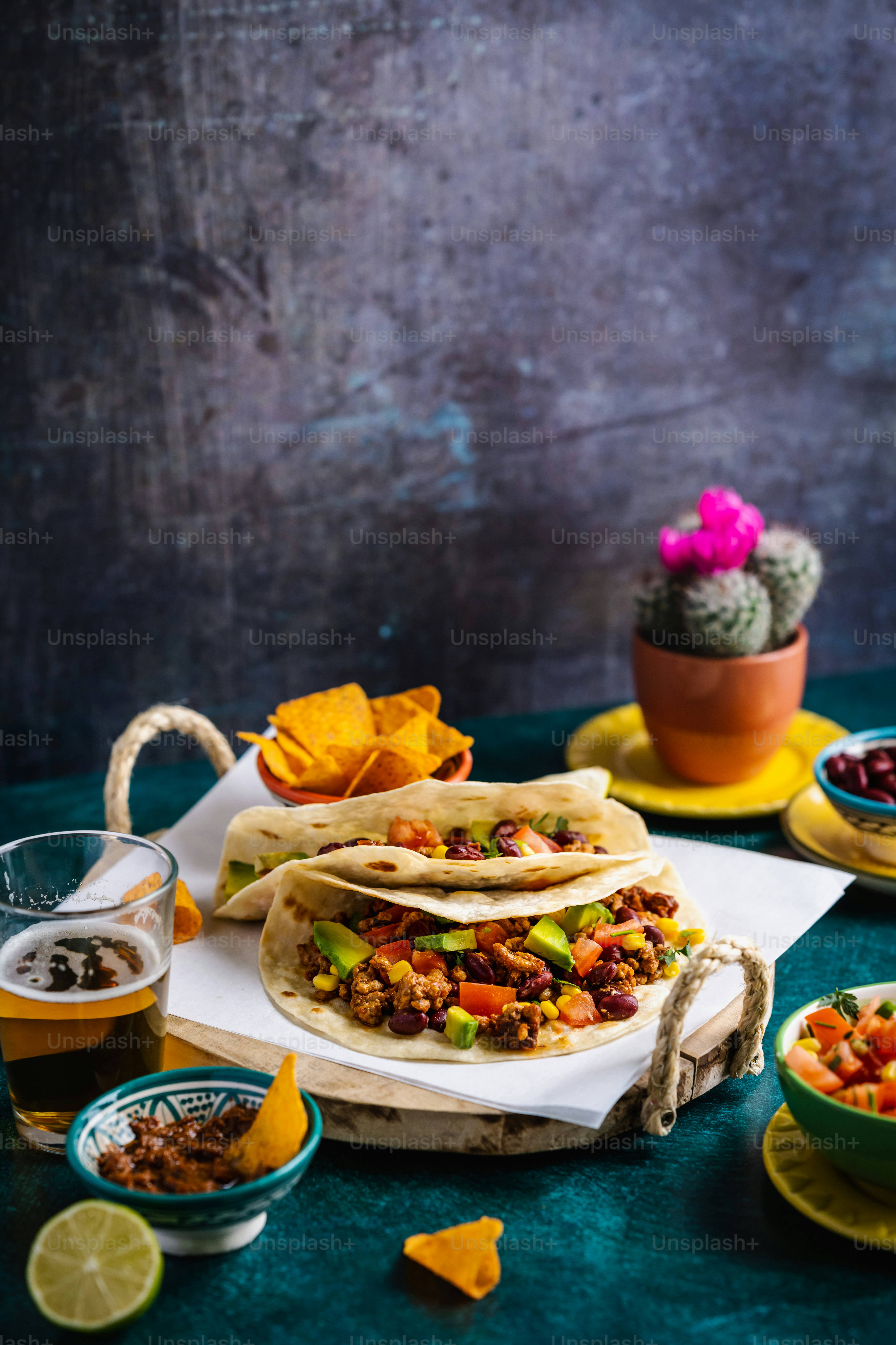 a table topped with tacos and bowls of salsa