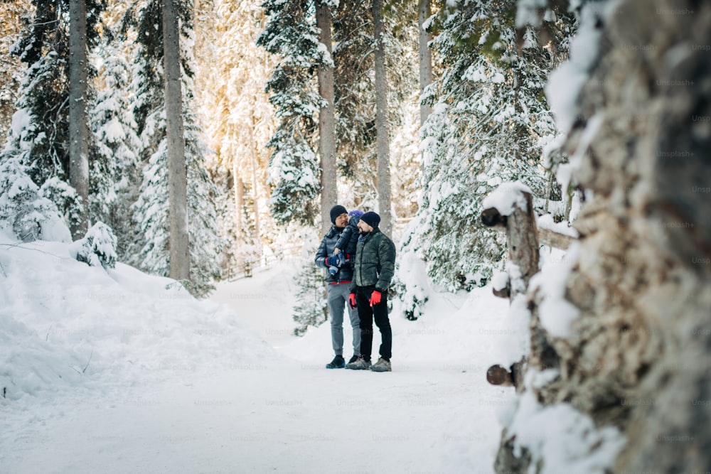 duas pessoas em pé no meio de uma floresta nevada