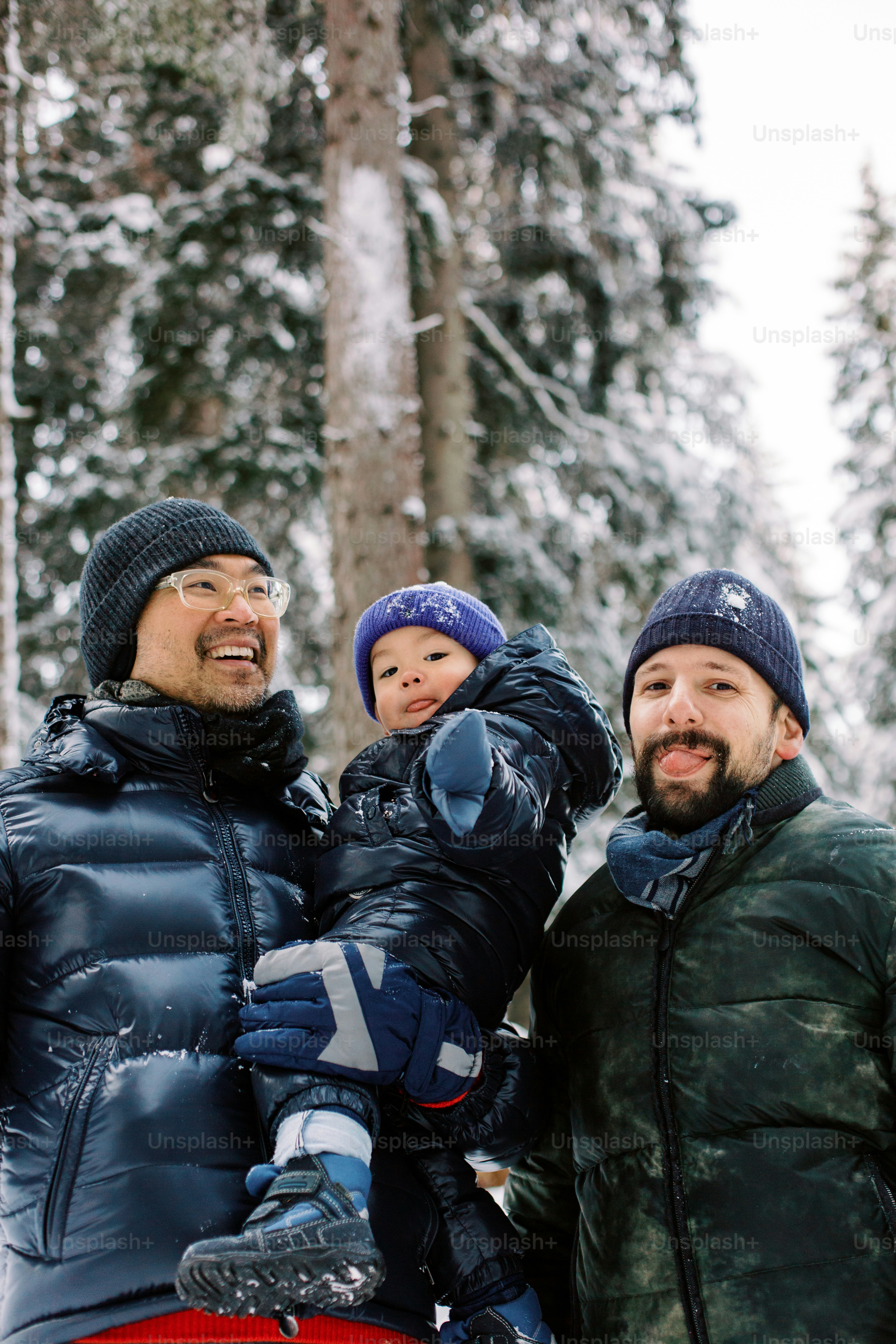 a man holding a child while standing next to another man