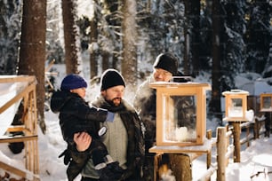 a man holding a child near a lantern in the snow