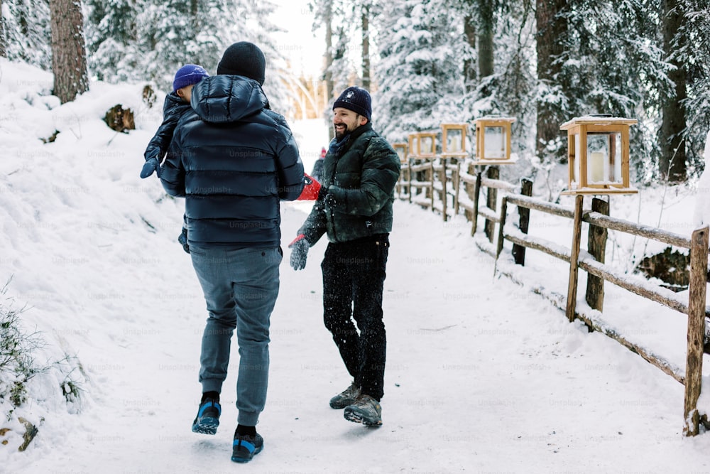 two men walking in the snow in the woods