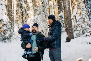 a man and a woman holding a child in the snow