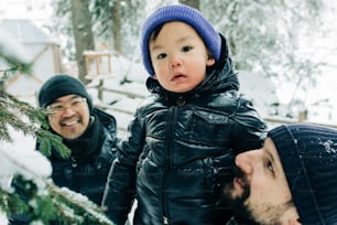 a man holding a small child near a tree