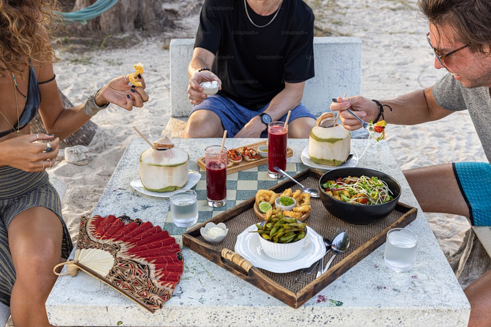 Un grupo de personas sentadas alrededor de una mesa comiendo alimentos