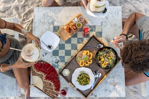 un gruppo di persone sedute intorno a un tavolo che mangiano cibo