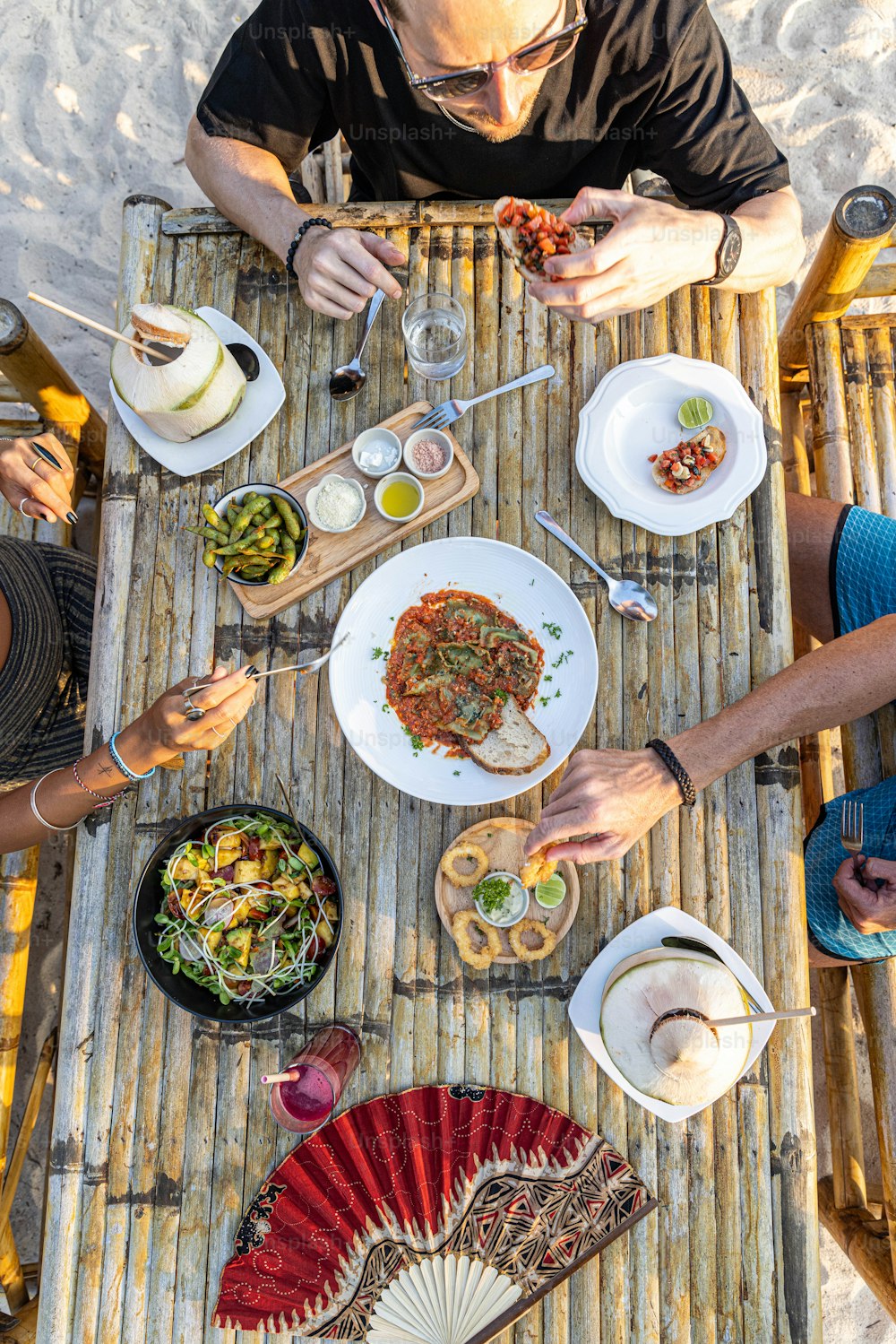 un groupe de personnes assises autour d’une table en train de manger de la nourriture