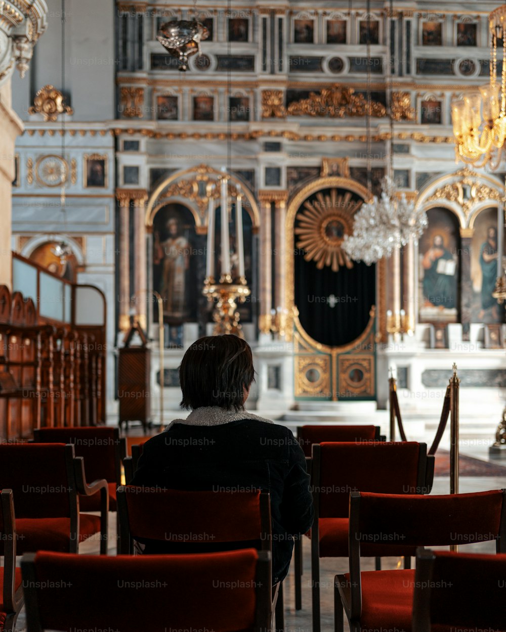 uma mulher sentada em uma cadeira em uma igreja