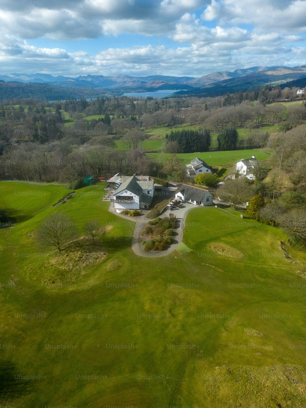 uma vista aérea de uma casa cercada por campos verdes