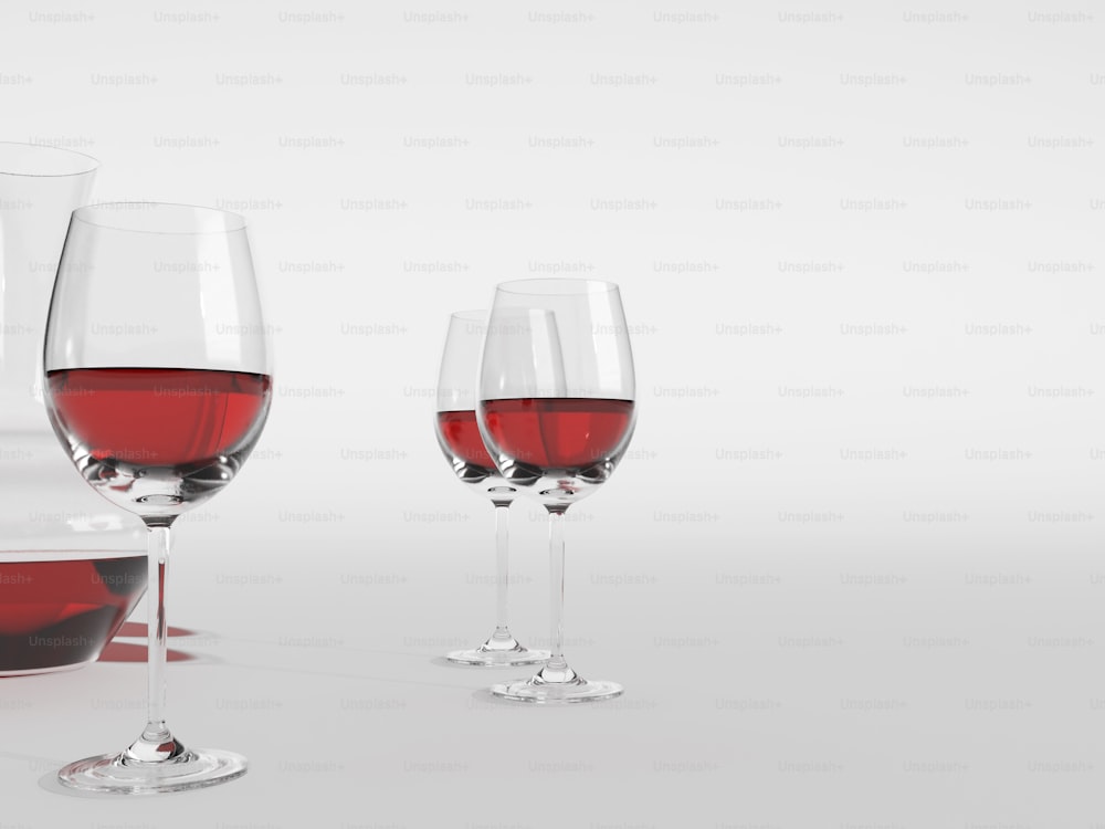 três taças de vinho tinto sentadas uma ao lado da outra