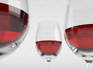 a close up of two wine glasses filled with red wine