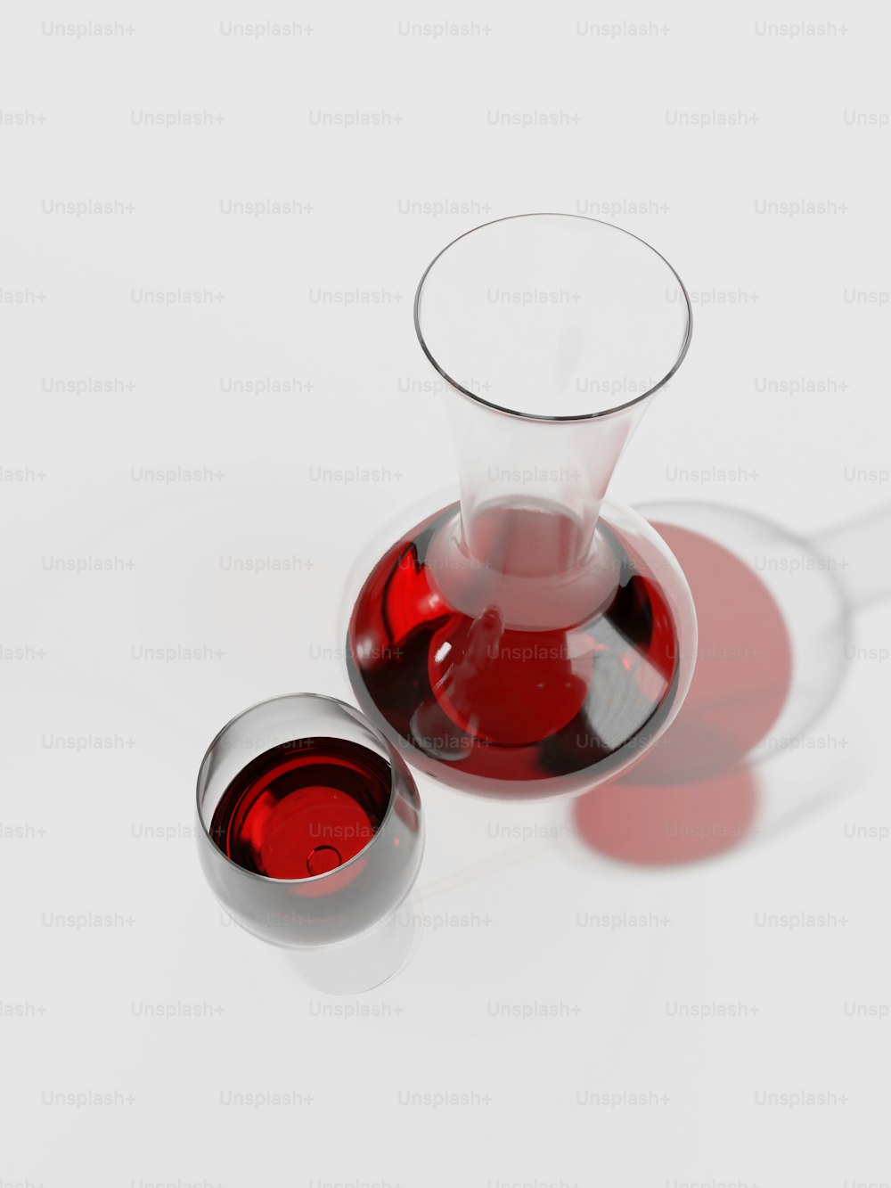 um copo de vinho tinto e um decanter de vinho