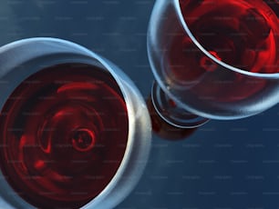a close up of two wine glasses filled with red wine