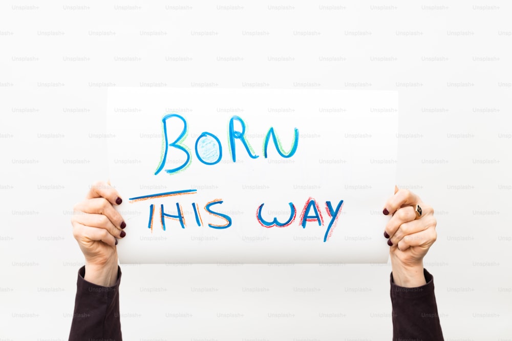 a person holding a sign that says born this way
