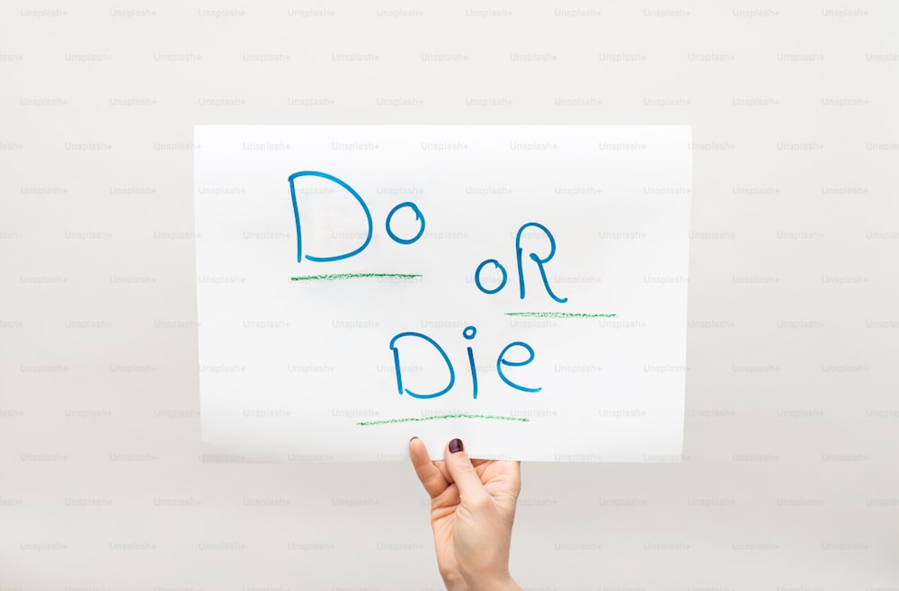 a person holding a sign that says do or die