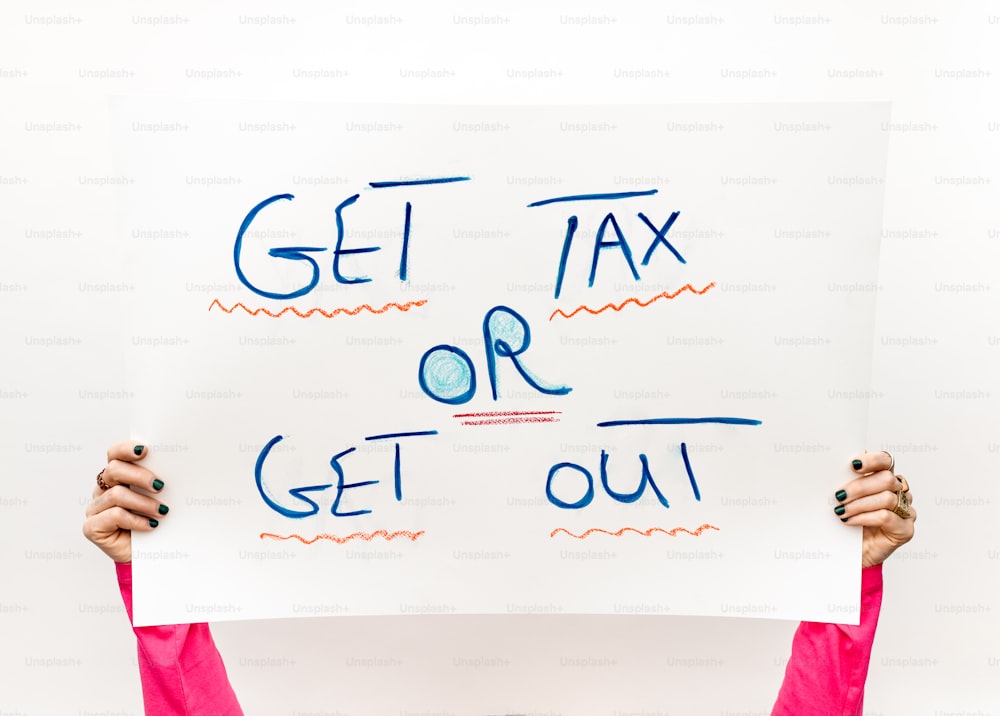 a person holding a sign that says get tax or get out