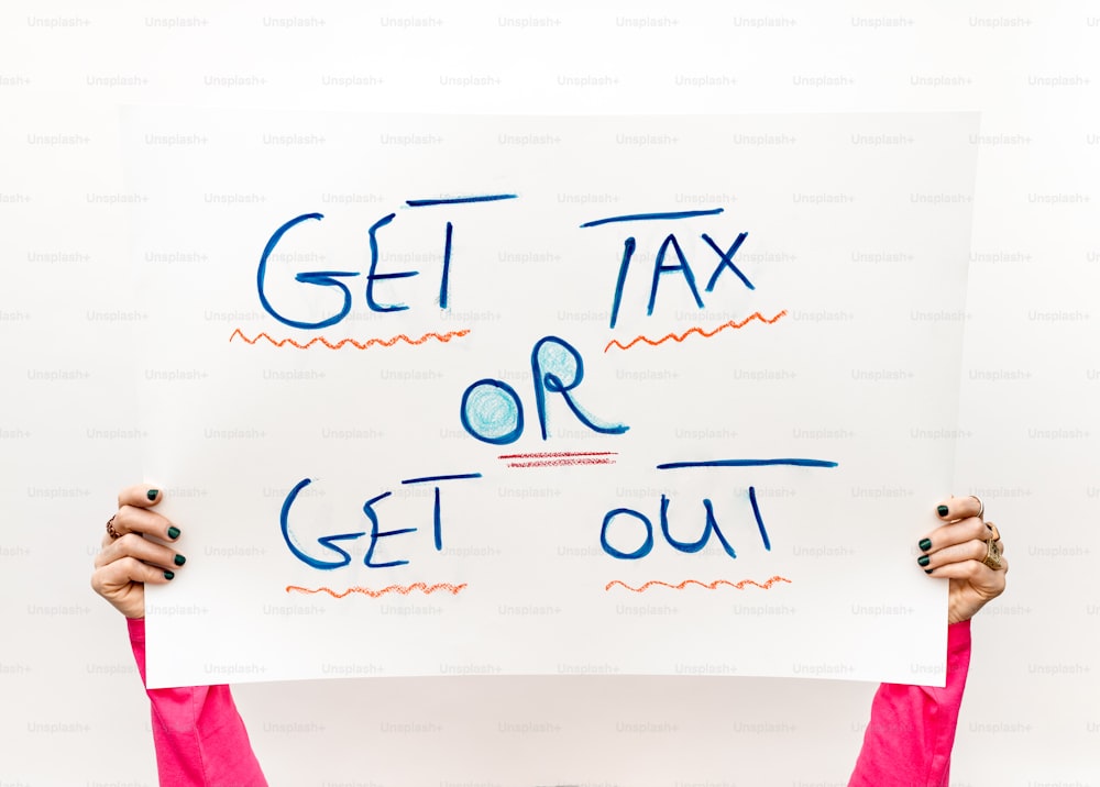 una persona con un cartello che dice Get Tax or Get Out