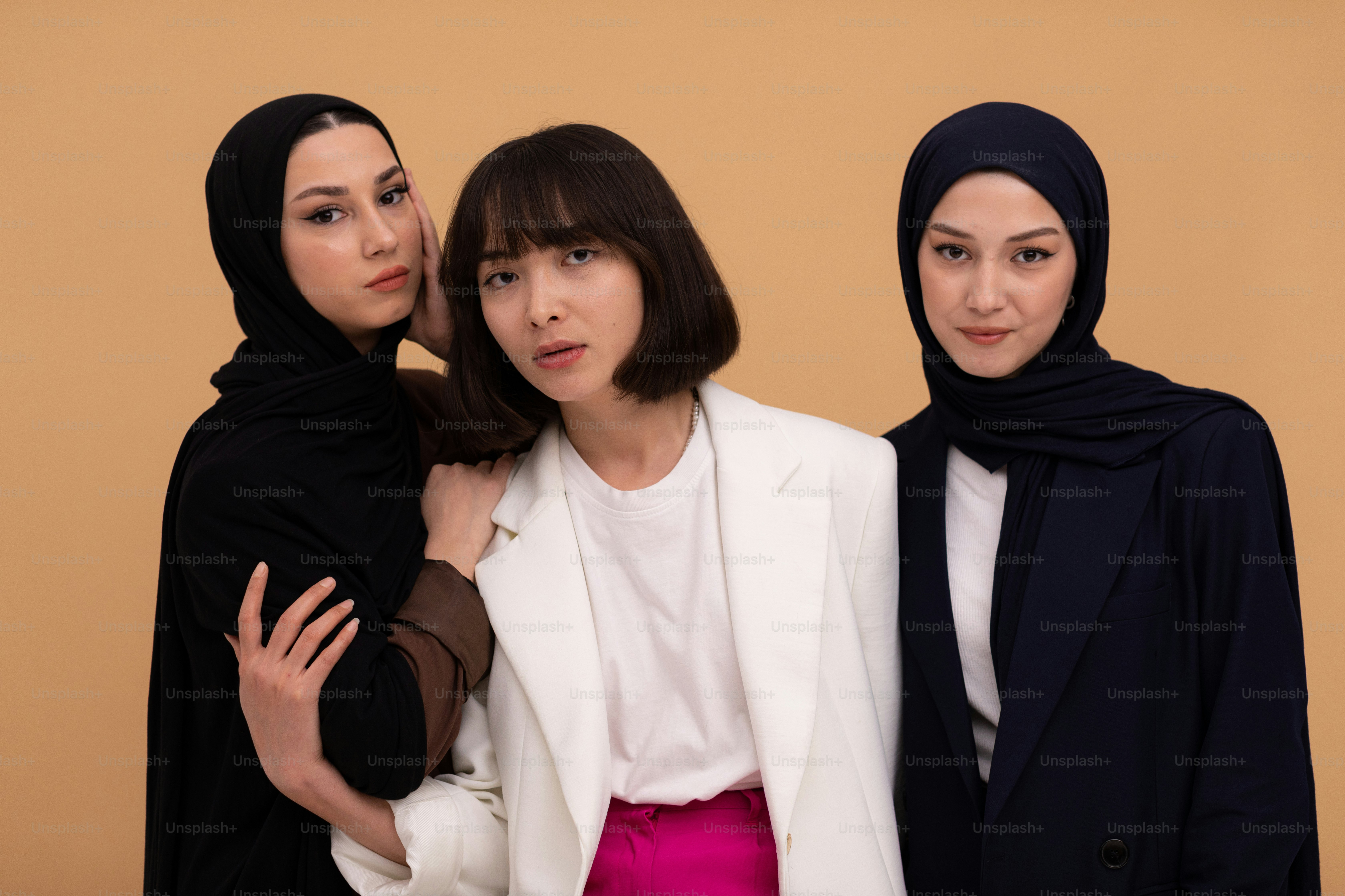 three women standing next to each other wearing headscarves