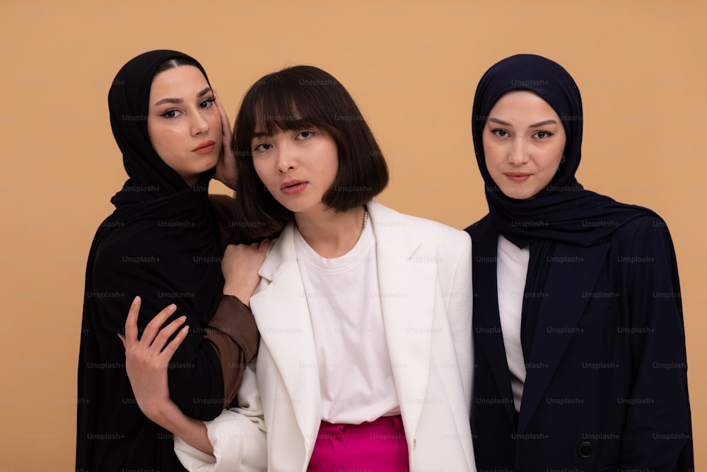 três mulheres de pé uma ao lado da outra usando lenços de cabeça