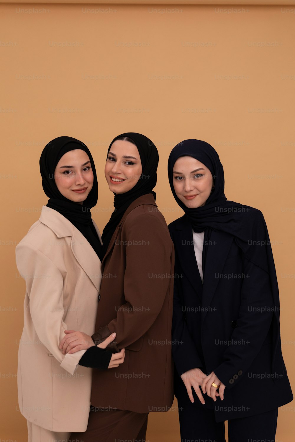 eine Gruppe von drei Frauen, die nebeneinander stehen