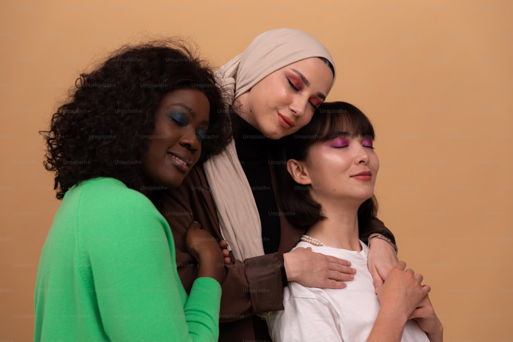 a group of three women standing next to each other